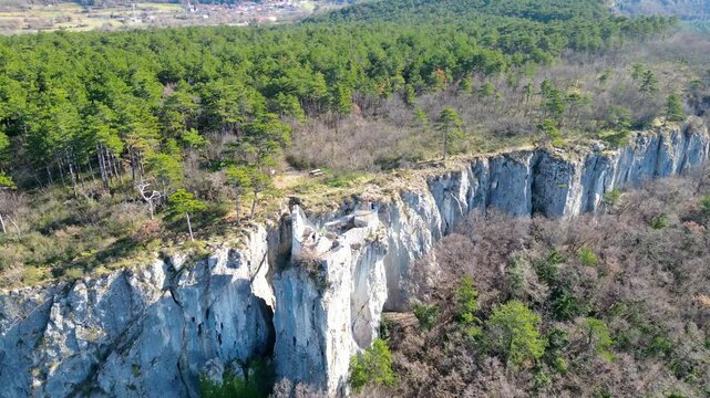 A stunning aerial drone view of Črni Kal, Slovenia, featuring the historic Castle of San Sergio atop a hill and the modern Črni Kal Viaduct, part of the A1 motorway (toll road), spanning Vipava Valley