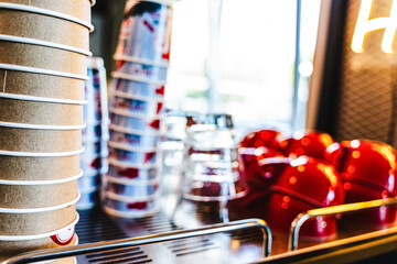Many ceramic red coffee cups on a coffee machine shelf in a cafe. Selective focus. Red coffee cups on a shelf in a cafe, second row of selective red cup with soft focus.
