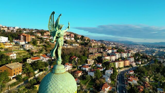 A breathtaking aerial drone view of the Faro della Vittoria (Victory Lighthouse) in Trieste, Italy. This iconic lighthouse, standing at 68 meters tall, is a symbol of victory