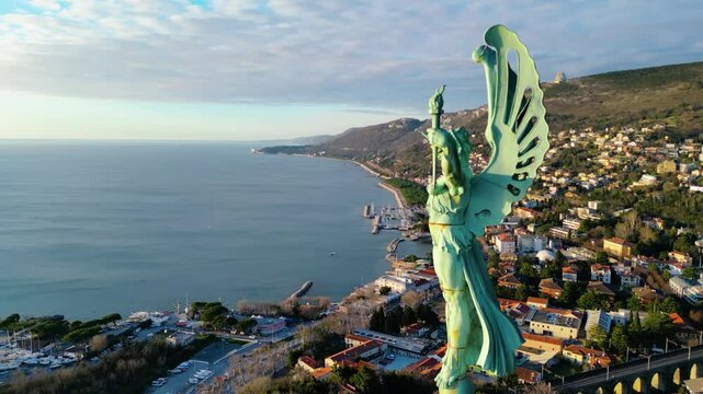 A breathtaking aerial drone view of the Faro della Vittoria (Victory Lighthouse) in Trieste, Italy. This iconic lighthouse, standing at 68 meters tall, is a symbol of victory