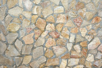 Masonry wall of natural brown stones with irregular pattern texture background. Part of typical...