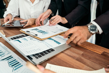 Diverse group of business analyst team analyzing financial data report paper on office table. Chart and graph dashboard by business intelligence analysis for strategic marketing planning Habiliment