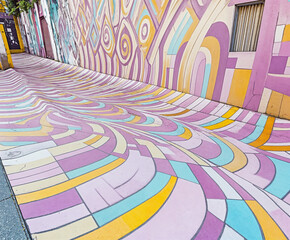 Vibrant Urban Alleyway with Colorful Geometric Wall and Ground Patterns