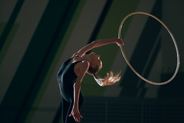 Rhythmic gymnast girl training in the gym.