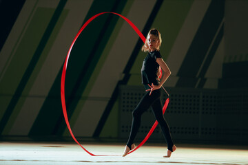 Rhythmic gymnast girl training in the gym.
