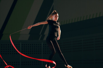 Rhythmic gymnast girl training in the gym.
