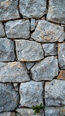 Layers of light gray stones create a beautiful, textured wall that exudes a timeless charm. Nature's artistry shines through the rugged surfaces, inviting admiration
