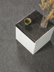 The aesthetic and minimalistic table stands on a colored carpet
