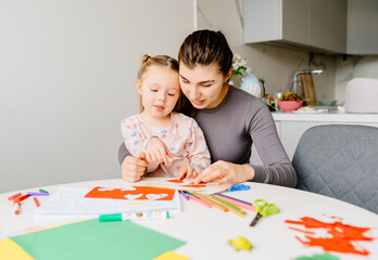Mom hugs daughter, helping her with applique. Natural parenting, family trust, imagination...