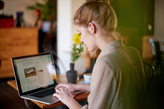 Laptop, typing and woman in cafe with content writing, travel blog and social media management. Planning, editing and freelancer girl in coffee shop with remote work, online research or website ideas