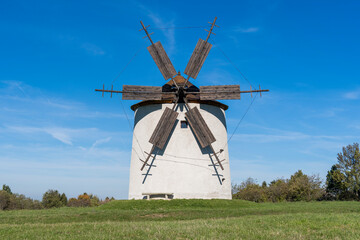 Rustic stone windmill in a grassy field