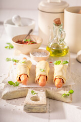 Unhealthy hot dogs baked in bright kitchen.