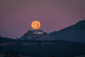 Sunset of the Moon over the castle of Archidona. Malaga. Spain.