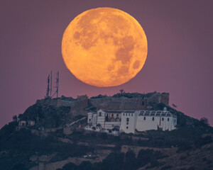 Sunset of the Moon over the castle of Archidona. Malaga. Spain.