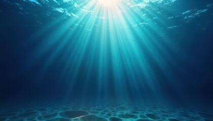 Sunlight beams through ocean water creating deep blue depths. Rays of light illuminate underwater surface. Tranquil underwater scene shows clear blue water. Ocean floor visible, showing textured