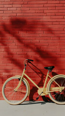 Fototapeta premium Pastel bicycle leaning against red brick wall, sunlit, palm shadow, urban setting, travel poster