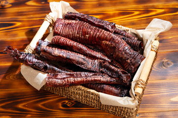Natural pet treats. Dried meat products for feeding and motivating dogs. Deer trachea in a wicker