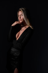 Beautiful young Russian woman in a black dress on a black background