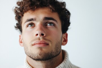 Obraz premium Thoughtful Young Man Looking Upwards in a Cozy Sweater