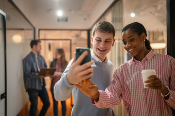 male and female diverse coworkers take a self portrait on cellphone
