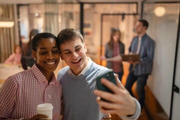 male and female diverse coworkers take a self portrait on cellphone