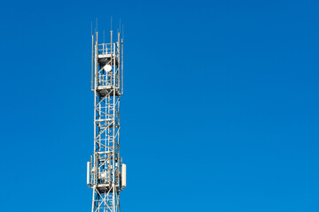 Telecommunication cell tower against clear blue sky in daylight