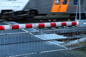 Train crossing barrier in action on urban railway tracks