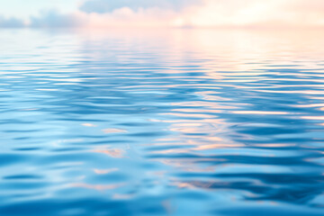 Fototapeta premium Calm water reflecting a soft, pastel sky at sunrise or sunset. Gentle ripples and serene colors create a peaceful atmosphere.