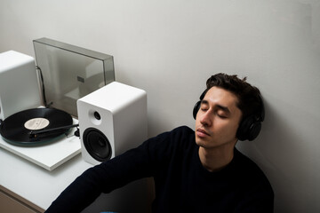 Romantic music lover is enjoying retro vinyl music from old vintage album with LP playing. Hi-Fi...