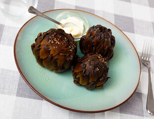 Concept of vegetarian food. Whole fried artichokes served with garlic mayonnaise dip..