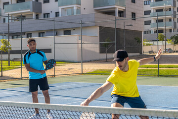 Two male pickleball players enjoying a match on a sunny day
