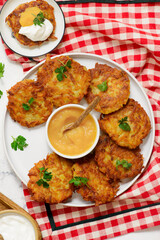 Traditional German potato latkes with applesauce and sour cream.selective focus