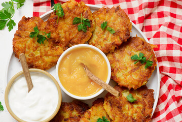 Traditional German potato latkes with applesauce and sour cream.selective focus