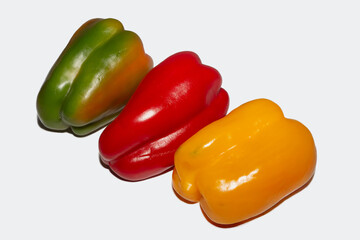 Green, Red, and Yellow Bell Peppers on White Background