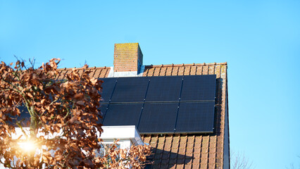 Solar panels on red tile roof of the house, close up