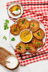 Traditional German potato latkes with applesauce and sour cream.selective focus