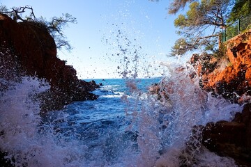Éclaboussures d'eau sur les roches de la calanque de Santa Lucia à Saint-Raphaël, avec tons vifs