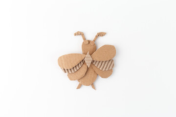 Paper insect crafted from brown paper on white background, cardboard activities for happy playtime, educational and imaginative project, recycling rubbish into creative handmade crafting ideas,
