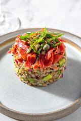 Superfood buckwheat tartare with avocado, capers and red onion, topped with serrano jamon slices