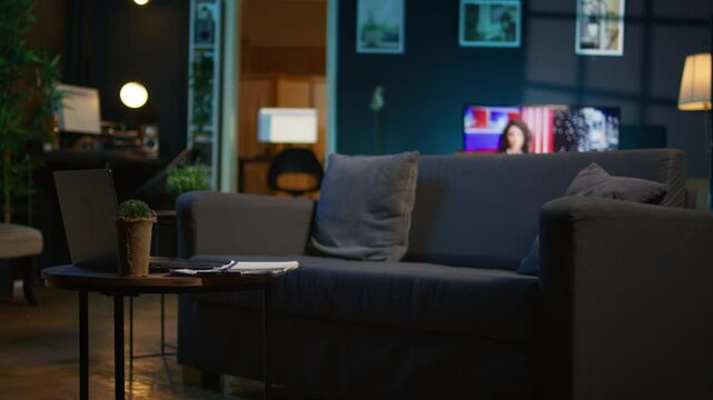 Contemporary apartment with modern indoor plants and neon lights creating a cozy casual living room with a smart tv and comfortable setup. Empty studio loft with trendy furniture.