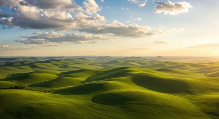 Fototapeta premium Serene green hills under a cloudy sky at sunset