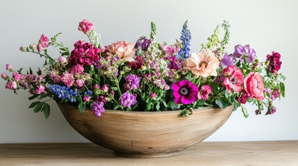 Fototapeta premium A wooden bowl artfully arranged with vibrant, fresh flowers, harmonizing rustic charm with the elegant simplicity of nature.