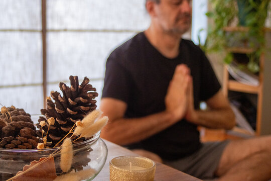 Man meditating and doing yoga in blurred background