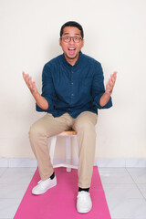A man sitting on the chair showing surprised expression