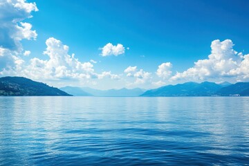 Serene lake view under a clear blue sky with fluffy clouds and distant mountains at midday. Generative AI