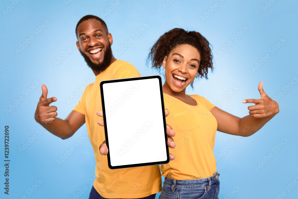 Poster joyful african american couple pointing at tablet screen with mockup for design, advertising new app