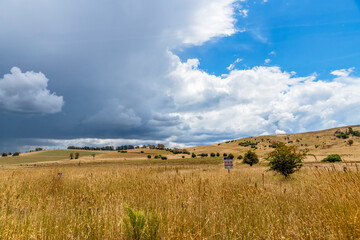 Countryside and storm clouds with blue sky