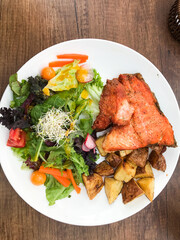 Grilled salmon with roasted potatoes and fresh salad in cusco restaurant