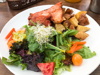 Grilled salmon with roasted potatoes and fresh salad in cusco restaurant