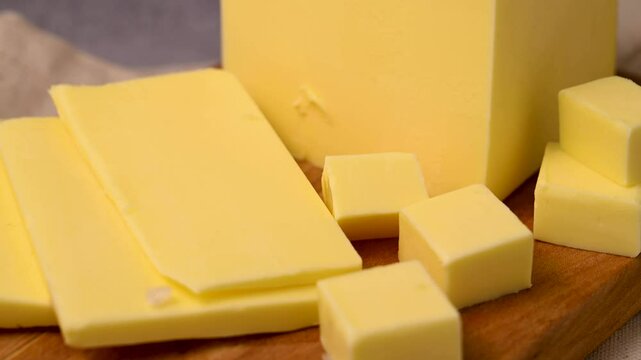 Butter block, grass-feed butter slices over wood cutting board. Vitamin D and source of fat 
